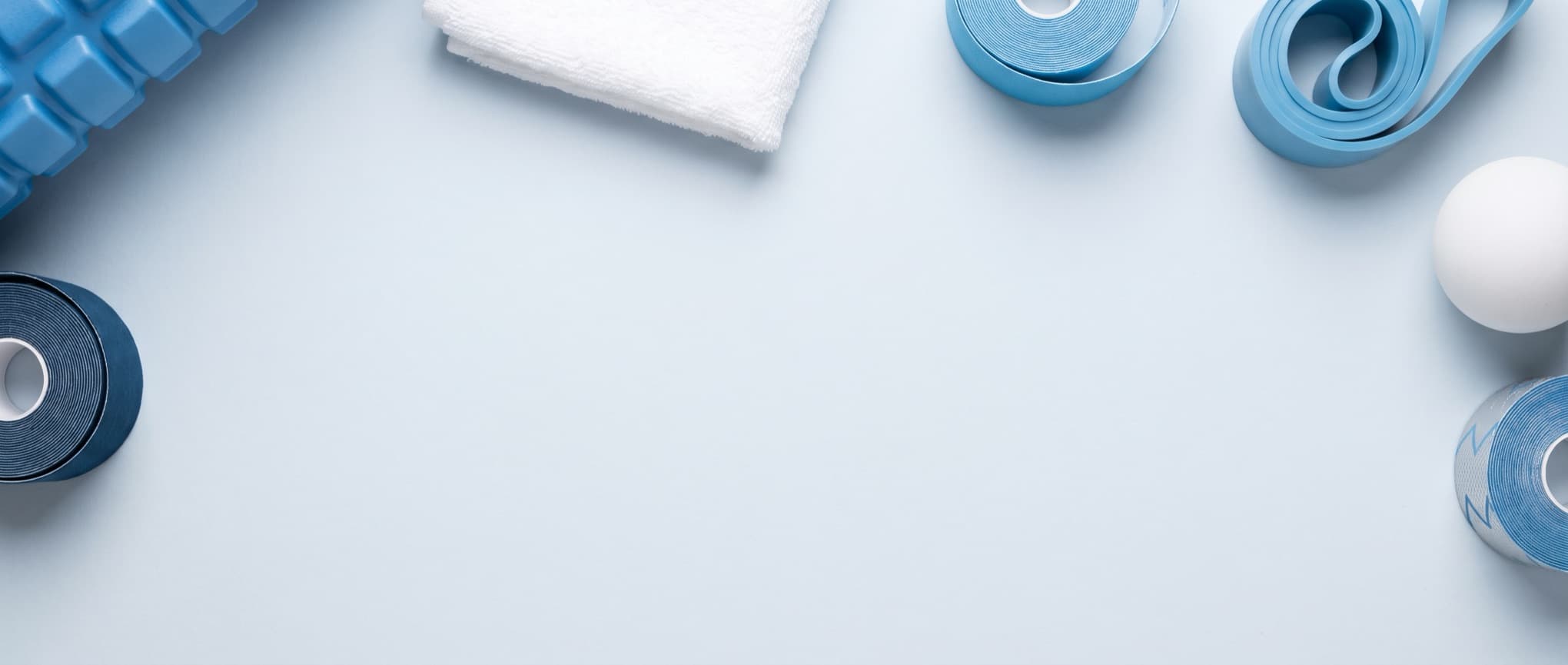 Physiotherapie-Material mit Faszienrolle, Kinesio-Tape, Therapieband und Handtuch